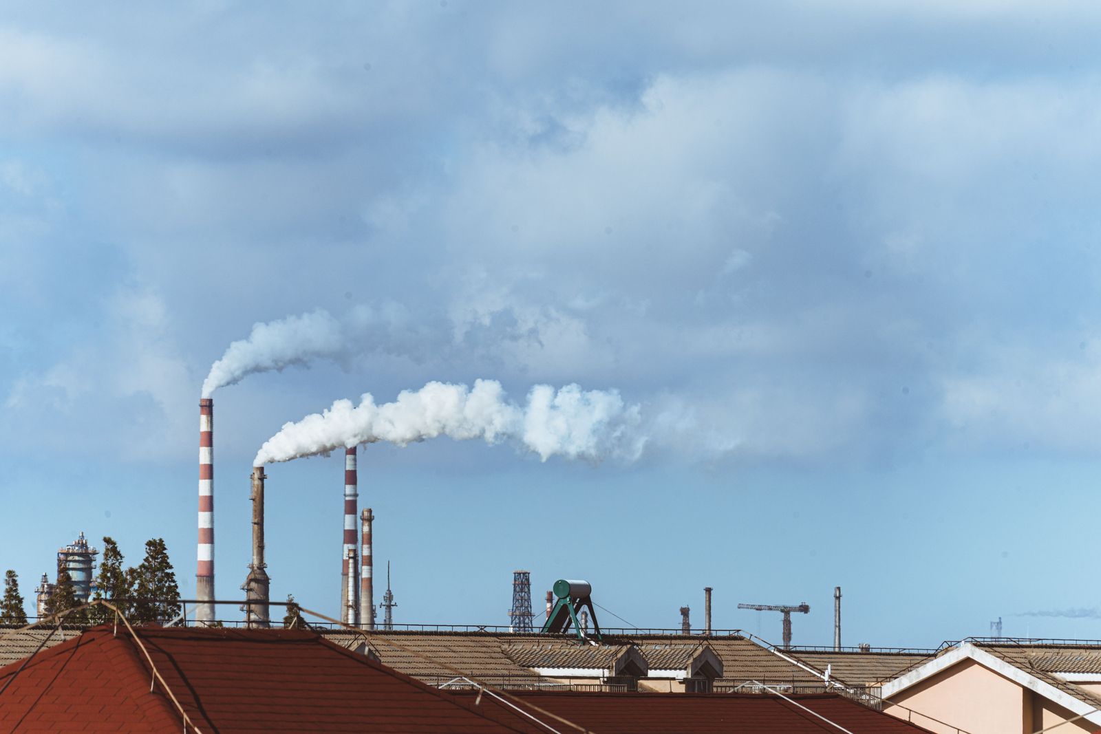 Industriële fabriek met rook boven een stedelijk gebied