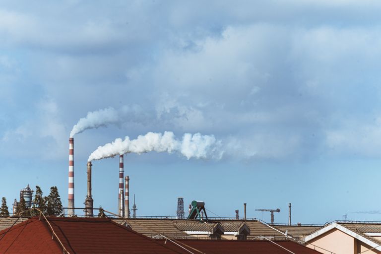 Industriële fabriek met rook boven een stedelijk gebied