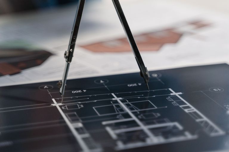 Close-up van een diagram met een passer voor het berekenen van projectgegevens